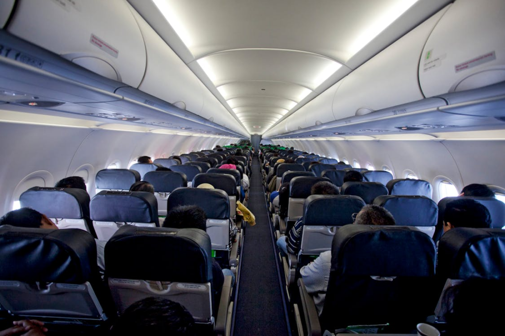 image of an airplane interior filled with people sitting