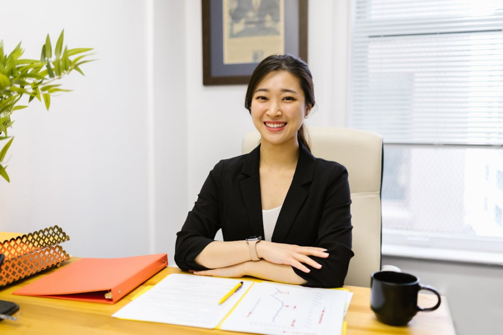 image of a female employee smiling while sitting on in front of a desk